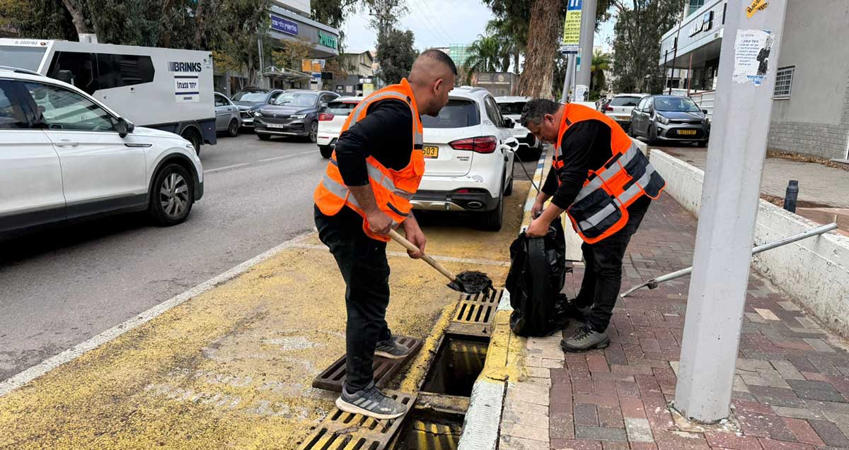 עובדי עיריית כפר סבא מנקים פתחי ניקוז ברחוב ראשי