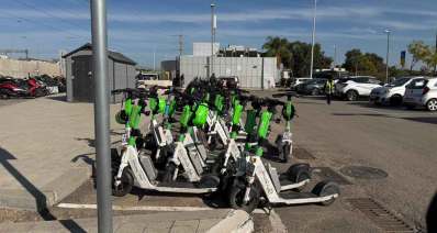 חניון קורקינטים תחנת רכבת הרצליה ומולו חניון לרכב.