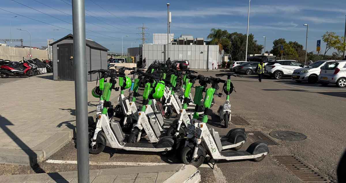 חניון קורקינטים תחנת רכבת הרצליה ומולו חניון לרכב.
