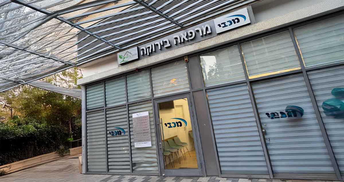 המרפאה של מכבי ברחוב אלתרמן הרצליה בקומת הקרקע. מעל הדלת שלט: מכבי מרפאה בירוקה. והשם מכבי על דלת הכניסה ועל הזכוכית בחוץ.