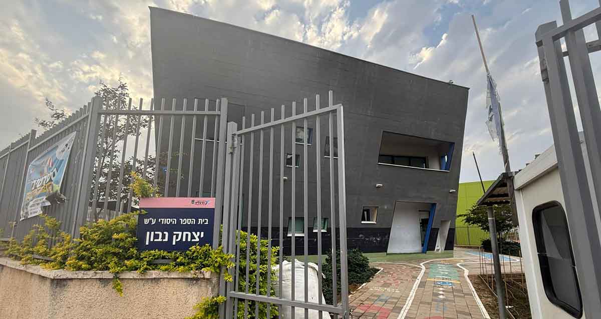 בית הספר היסודי נבון ברחוב אלתרמן הרצליה. שער מתכת פתוח בכניסה לבית הספר, ותמונה של הבניין עם חזית משופעת.