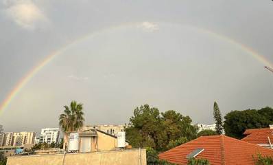 קשת בענן מעל גגות הבתים בהרצליה.