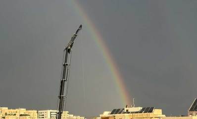 קשת בענן בהרצליה. מנוף וגגות בתים