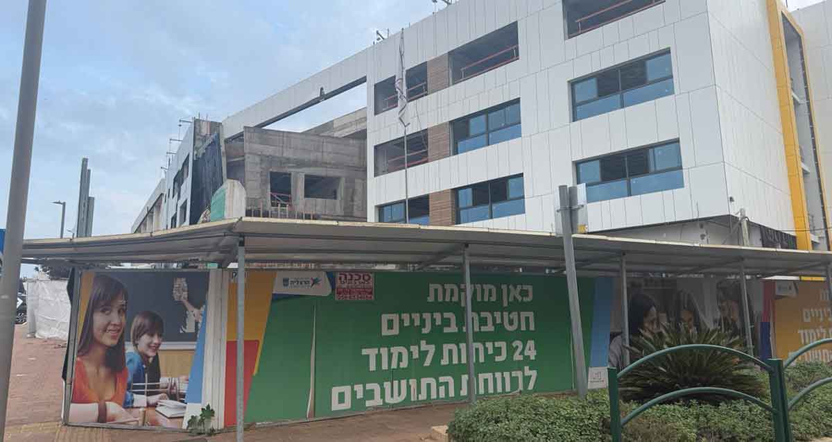 אתר הבנייה של חטיבת הביניים אלתרמן ברחוב רש"י בהרצליה הירוקה המערבית. בניין של ארבע קומות. על הגדר כיתוב: כאן מוקמת חטיבת ביניים 24 כיתות לימוד לרווחת התושבים.