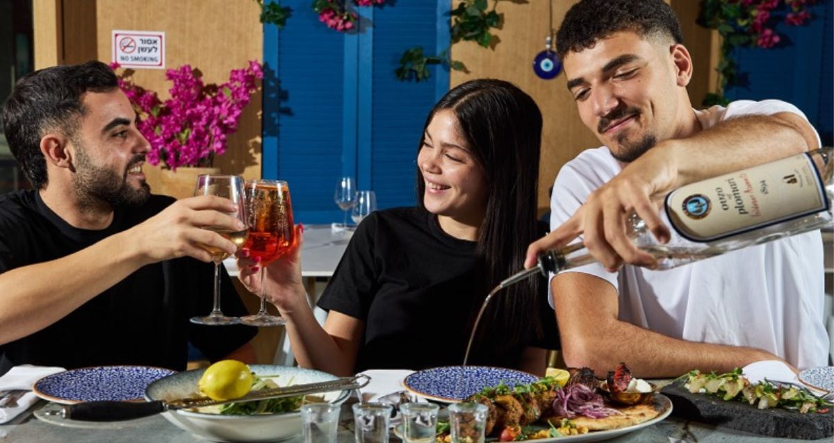 2 בנים ובת יושבים על הבר עם אוכל ואלכוהול, צילום: מתן אביב