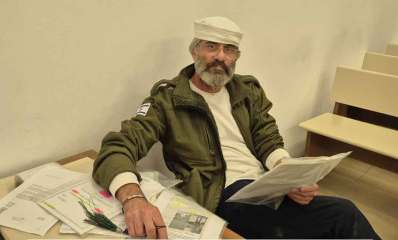 אסף חוג'ה. יושב ליד שולחן עם מסמכים