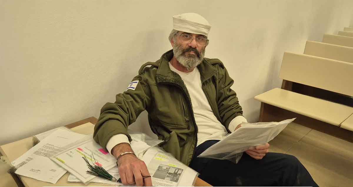 אסף חוג'ה. יושב ליד שולחן עם מסמכים