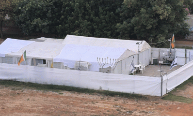 מתחם אוהל בית הכנסת בכפר סבא. מכוסה בשתי יריעות בד לבנות. ליד הגדר חנוכייה.