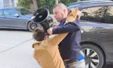 ירון גדות נאבק במפגין. אוחז מגאפון ביד