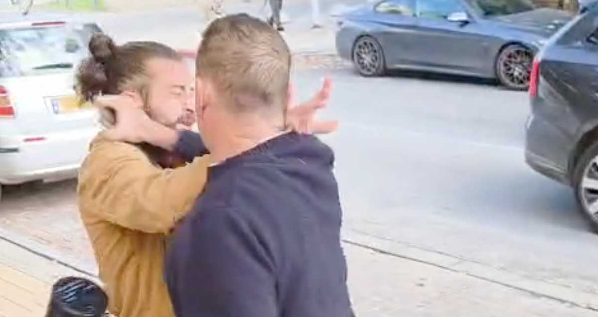 ירון גדות נאבק במפגין. אוחז מגאפון ביד