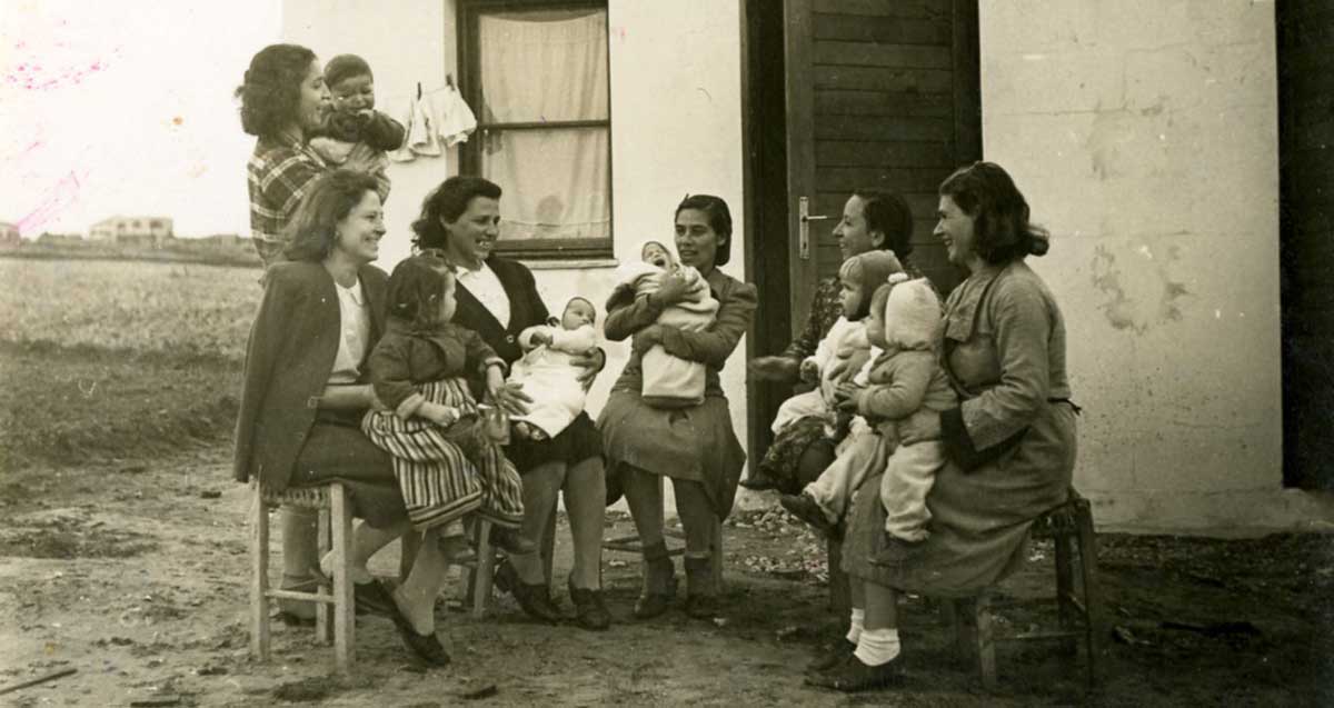 תמונה בשחור לבן. עולות מטורקיה עם ילדיהן בשיכון שבזי