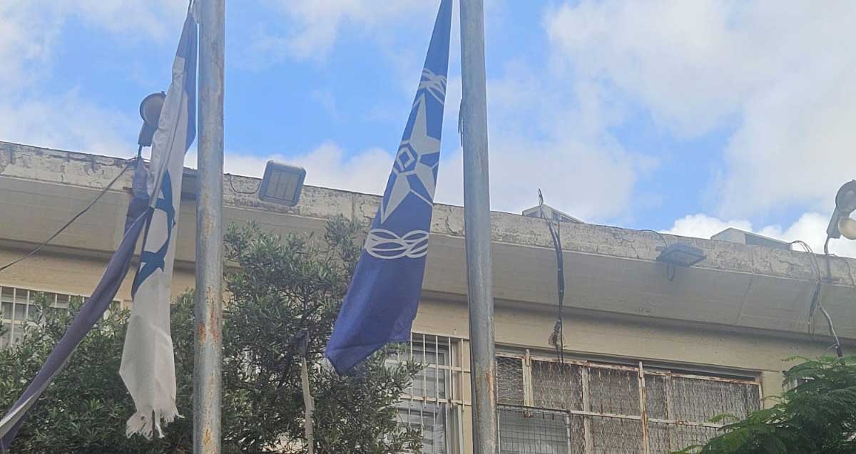 דגל ישראל קרוע בכניסה לתחנת המשטרה ברחוב טרומפלדור לידו מתנוסס דגל משטרת ישראל