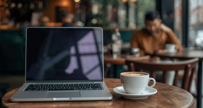 שולחן בבית קפה עם לפטופ וכוס קפה, הדמיית בינה מלאכותית: שרון אונליין