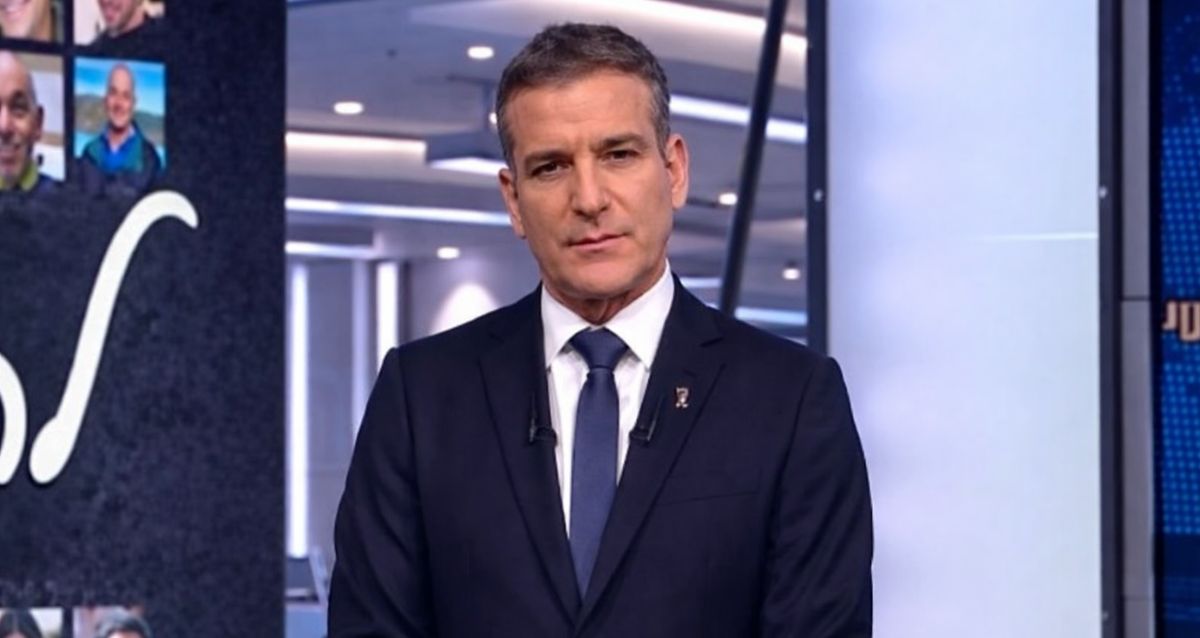 דני קושמרו בחליפה ועניבה כחולה באולפן החדשות, צילם: מתוך אולפן שישי, חדשות 12