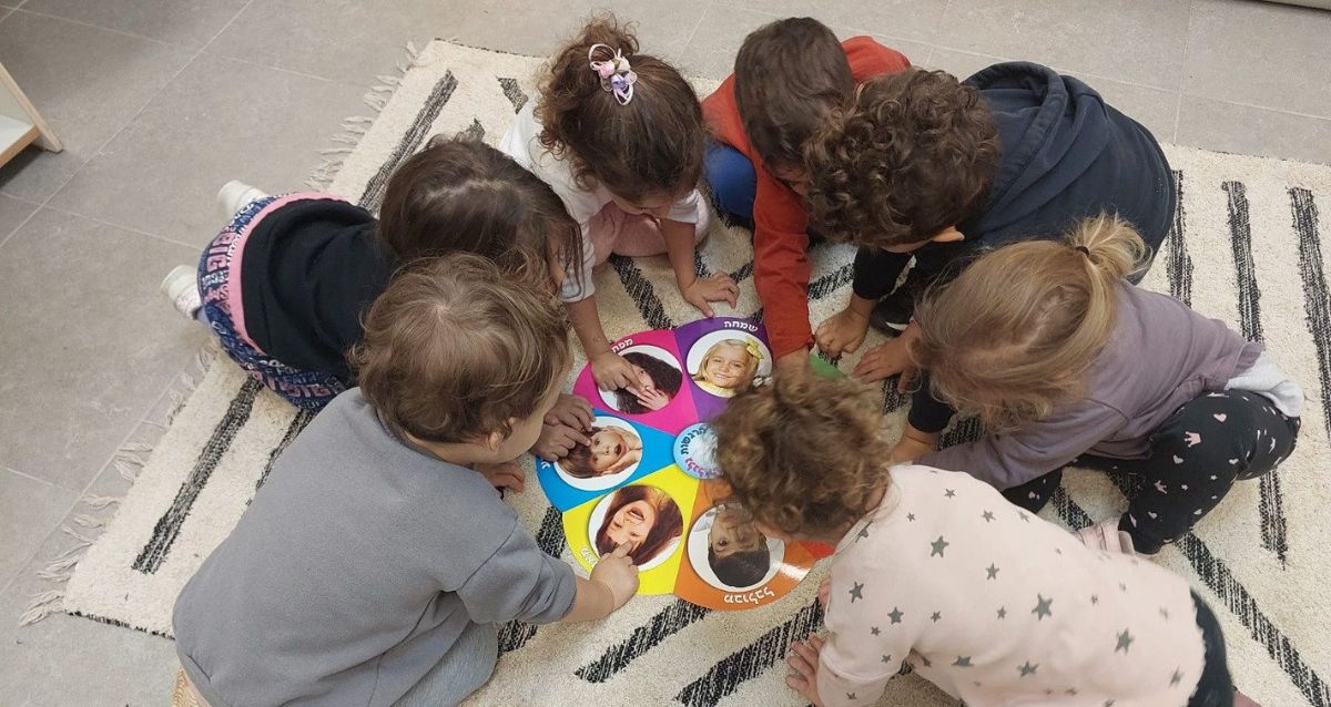 קבוצת ילדים צעירים יושבים בממעגל ומשחקים, צילום מלמעלה, צילום: עיריית כפר סבא