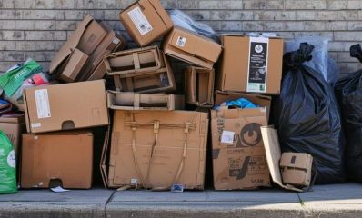 ערימת קרטונים ברחוב ליד שקיות אשפה, הדמיית בינה מלאכותית: שרון אונליין