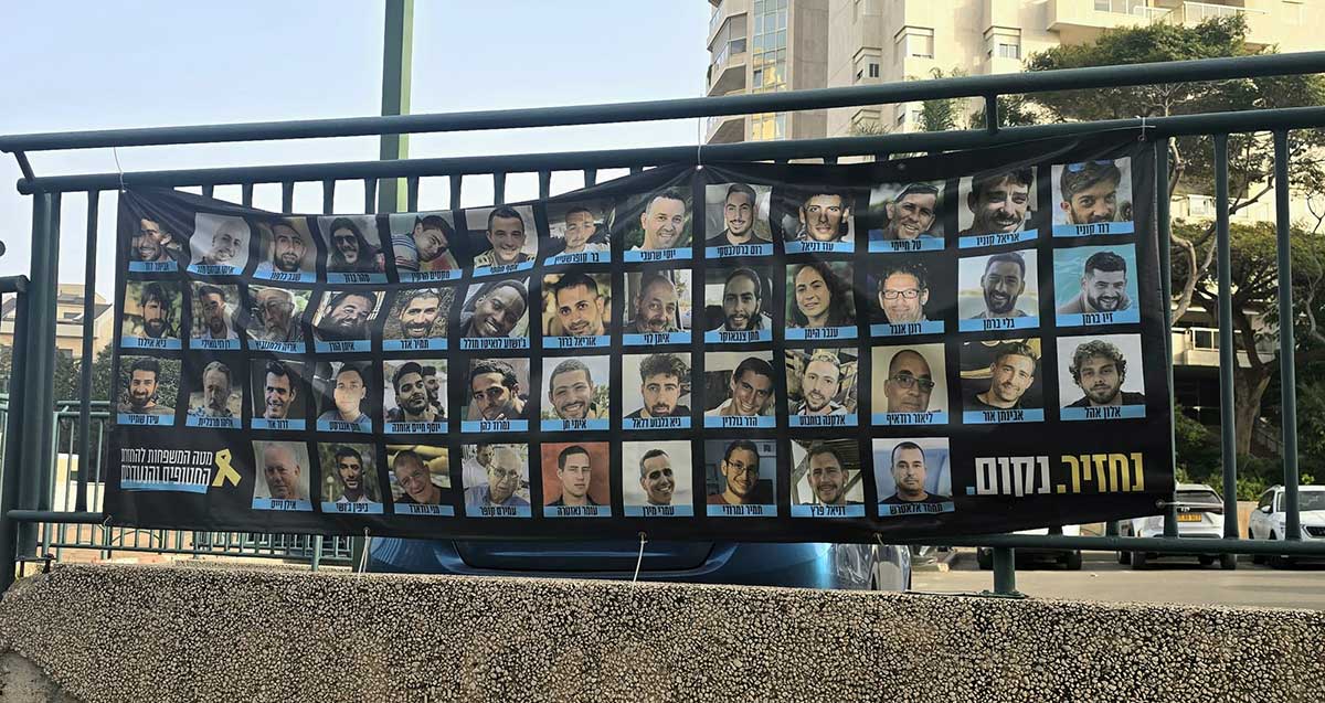 שלט ישן להשבת החטופים בשכונת צמרות על גדר.