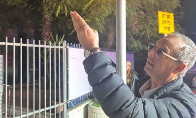 איציק רוכברגר ליד שער המשטרה הנעול מצביע על הבניין התחנה