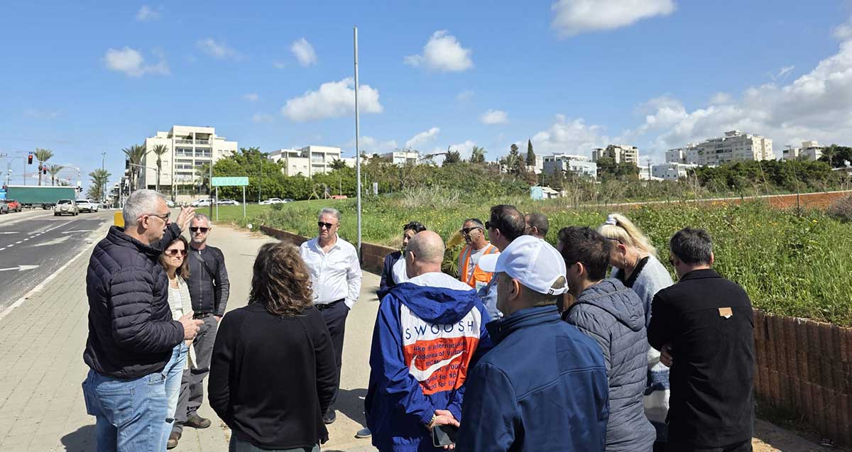 מימין - השטח שיהפוך לפארק בצומת הכפר הירוק. אנשי העירייה עומדים במדרכה ליד השטח.
