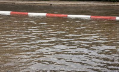 כביש מוצף במים שמגיעים עד לגובה המדרכה שצבועה באדום לבן, צילום: פרטי