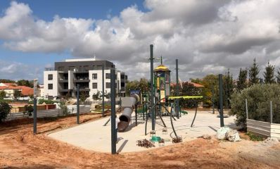 מתקני משחק לילדים על שטח חולה, ברקע בינייני מגורים, צילום: עיריית רעננה