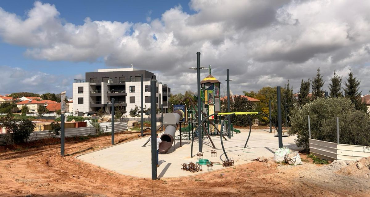 מתקני משחק לילדים על שטח חולה, ברקע בינייני מגורים, צילום: עיריית רעננה