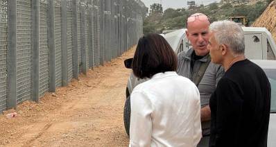 יאיר לפיד בקו התפר באזור השרון, ליד הגדר עם אישה וגבר.