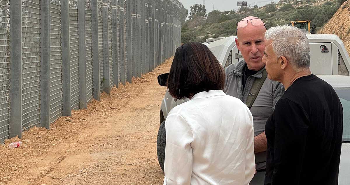 יאיר לפיד בקו התפר באזור השרון, ליד הגדר עם אישה וגבר.