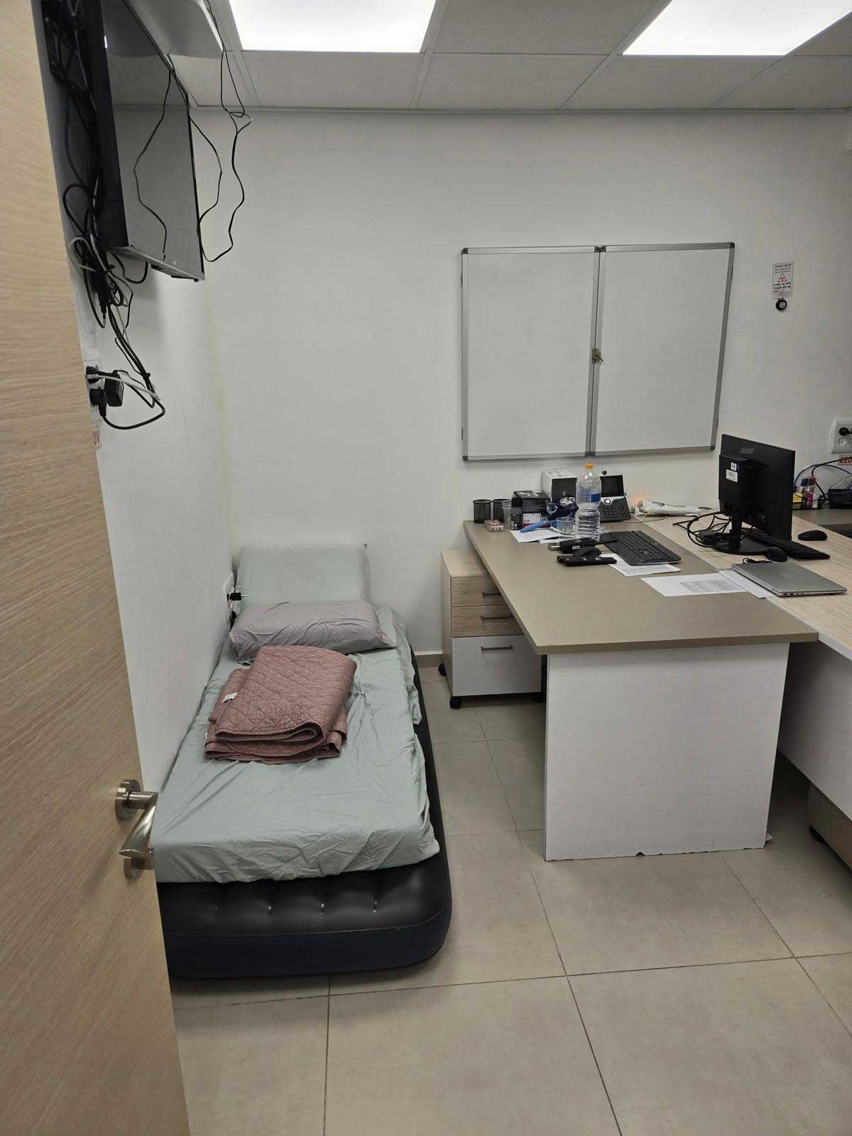 המשרד של ברוידא. שני שולחנות ומיטה