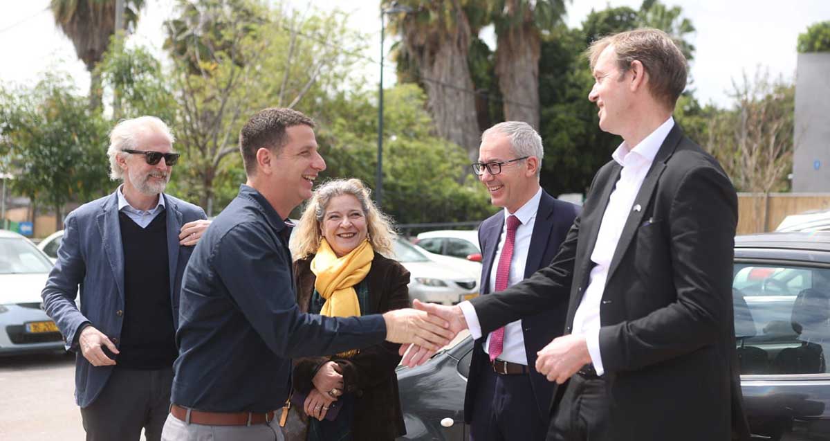 יריב פישר עם שגרירי המדינות. יריב לוחץ יד עם שגריר, ולידם עוד שני שגרירים.