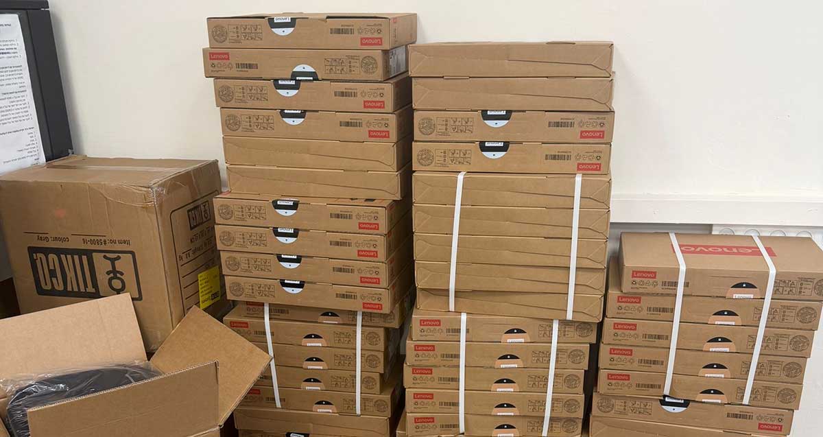 מחשבים שהזמינו ילדי וילדות כפר סבא במבצע המוזל. ערימות של קרטונים עם מחשבים.