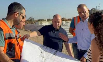 רפי סער בפרויקט קריית הצעירים, עם עוד אנשים האוחזים מפה.
