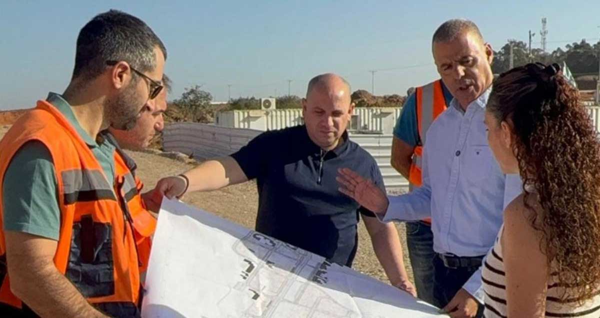 רפי סער בפרויקט קריית הצעירים, עם עוד אנשים האוחזים מפה.