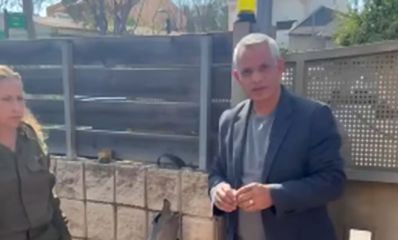 אלברט טייב עומד בחצר בית ליד נציגת פיקוד העורף ביניהם שבר יירוט, צילום: מתוך הפייסבוק של אלברט טייב