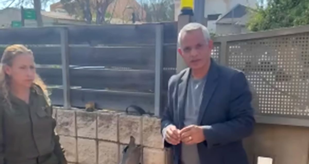 אלברט טייב עומד בחצר בית ליד נציגת פיקוד העורף ביניהם שבר יירוט, צילום: מתוך הפייסבוק של אלברט טייב
