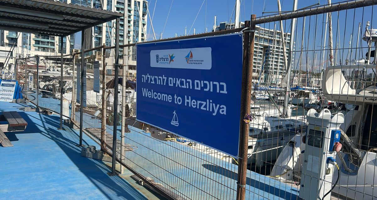 שלט ברוכים הבאים להרצליה על רקע המרינה, צילום: עיריית הרצליה