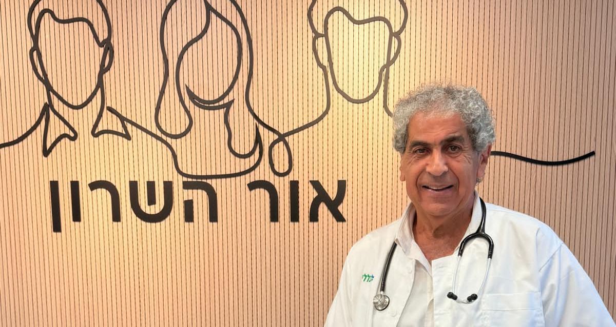 פרופסור עובדי דגן עומד עם חלוק לבן על רקע קיר המרפאה, צילום: כללית