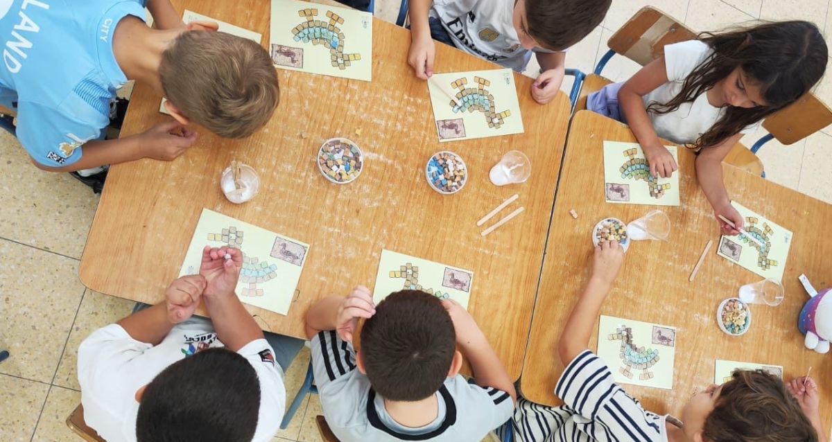 מבט על: ילדים יושבים סביב לשולחן ועוסקים בפעילות יצירה בצהורן, צילום: עיריית כפר סבא