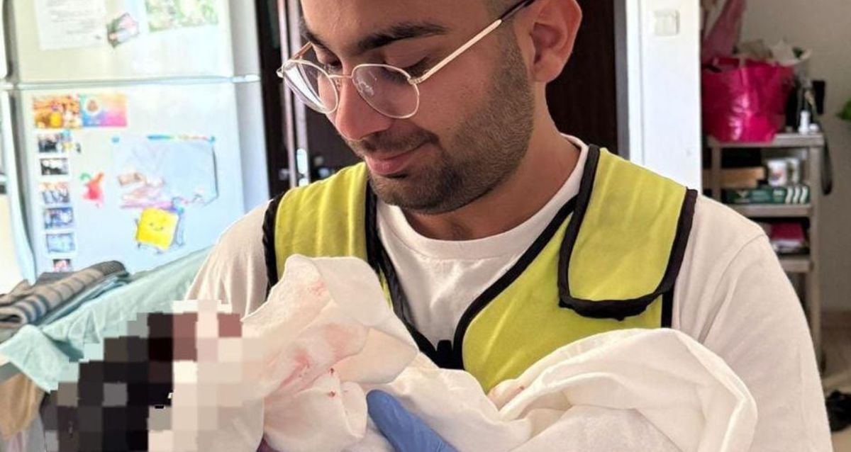 פראמדיק מחזיק את התינוקת שנולדה, צילום" מד"א