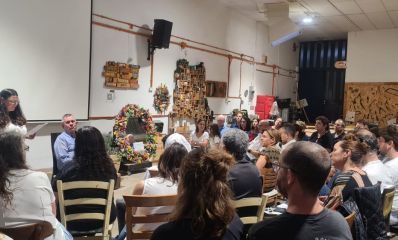 אנשים יושבים באירוע זיכרון בסלון בשנת 2025, צילום: עיריית כפר סבא