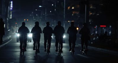 נערים רוכבים על קורקינט בלילה בנוף עירוני, הדמיית בינה מלאכותית: שרון אונליין