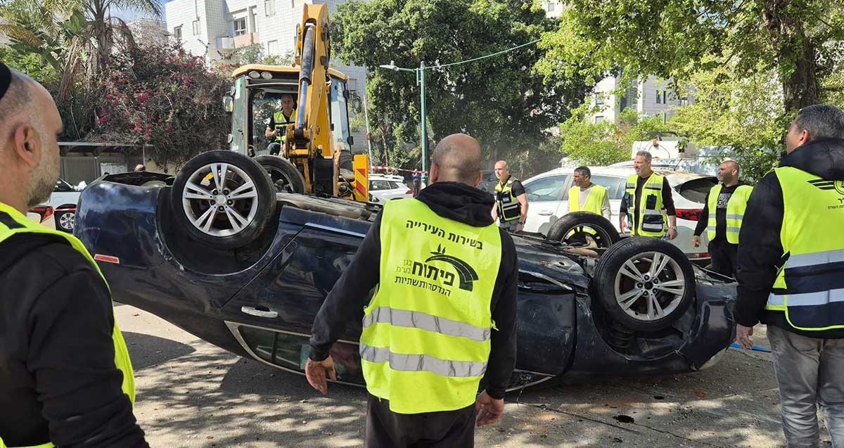 טרקטור של העירייה מעמיד בחזרה (על צמיגים) את הרכב שהתהפך מהדף טיל איראני ברמת השרון