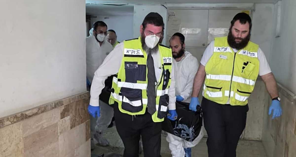 אישה בת 70 נמצאה בביתה ברמת השרון במצב של ריקבון. אנשי זק"א עם אלונקה נושאים את הגופה.