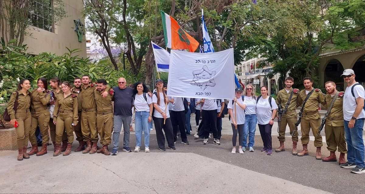 תלמידים וחיילים עם דגלי ישראל במסע כולם בשביל אחד, צילום: עיריית כפר סבא