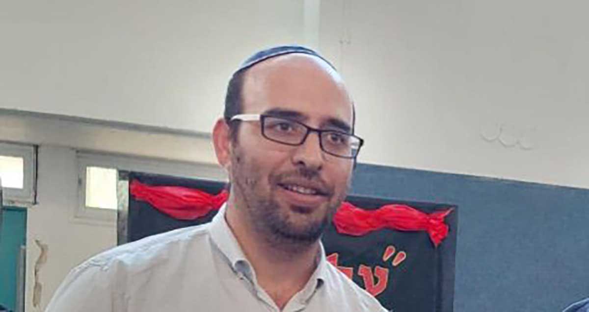 צילום פנים של מנהל בית הספר בר אילן בכפר סבא אריאל טיבי. מרכיב משקפי ראייה וחובש כיפה.
