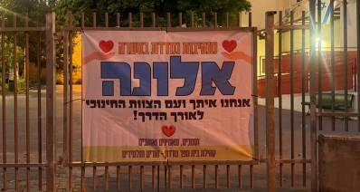 שלט עידוד למנהלת בית הספר גורדון בכפר סבא. השלט מוצב על גבי גדר בית הספר. בשלט כתוב: מנהיגות נמדדת בסערה. אלונה אנחנו עיתך ועם הצוות החינוכי לאורך הדרך! תומכים, מאמינים ואוהבים. קהילת בית ספר גורדון - הורים ותלמידים