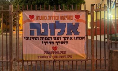 שלט עידוד למנהלת בית הספר גורדון בכפר סבא. השלט מוצב על גבי גדר בית הספר. בשלט כתוב: מנהיגות נמדדת בסערה. אלונה אנחנו עיתך ועם הצוות החינוכי לאורך הדרך! תומכים, מאמינים ואוהבים. קהילת בית ספר גורדון - הורים ותלמידים