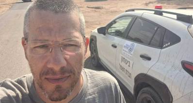חבר מועצת העיר הרצליה דניאל צ׳רטוק לצידו ניידת ביטחון של חברת החשמל ומאחוריו טרקטור