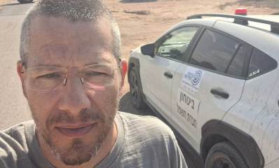 חבר מועצת העיר הרצליה דניאל צ׳רטוק לצידו ניידת ביטחון של חברת החשמל ומאחוריו טרקטור