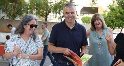 רפי סער בשבוע הספר בעיר ביוני 2026. עם ספר ילדים בידיו ואישה בכל צד שלו.